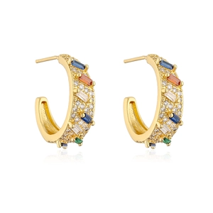 Detailed view of C-shaped gold earrings with colorful zircon stones and white rhinestones