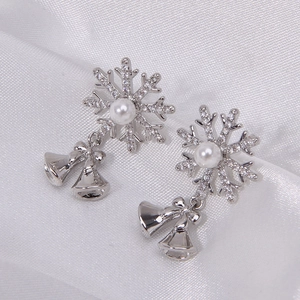 Sparkling snowflake bell drop earrings with rhinestones and pearls on white silk