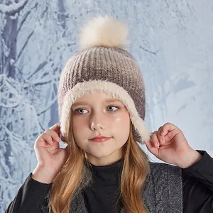 Kids winter knit trapper hat with pompom and earflaps in warm brown and beige colors