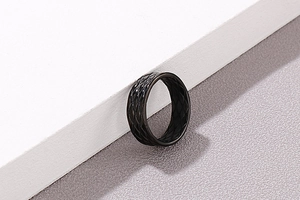 Detail of a black matte ring featuring a sophisticated geometric diamond mesh pattern