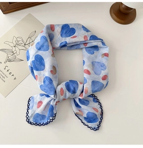 Detailed close-up of blue floral cotton scarf with hand-painted hearts and crochet lace edge