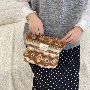 Close-up of geometric pattern plush makeup bag with colorful sozakka beauté label