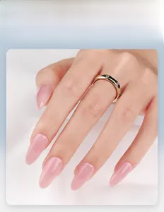 Dettaglio di unghie finte a mandorla corte rosa gelatina indossate con anello d'oro
