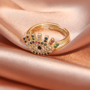 Macro detail of adjustable evil eye ring with multi-colored crystals on silk background