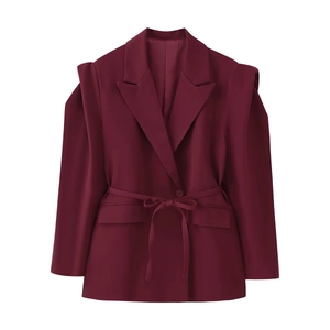 Détail du blazer bordeaux avec ceinture et épaulettes structurées, texture lisse