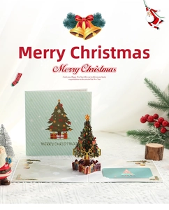 Gros plan de la carte de Noël 3D avec sapin pop-up, boîte cadeau et enveloppe verte
