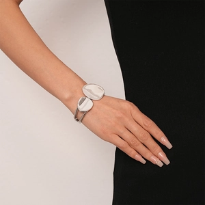 Detail of silver irregular geometric double-layer open bangle on a model's wrist