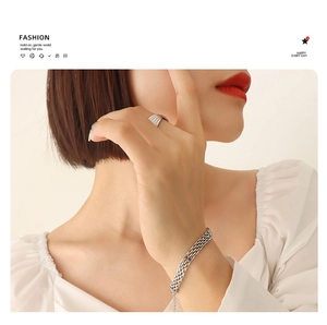 Detailansicht von geflochtenem Silberarmband und strukturiertem Metallring in elegantem Design