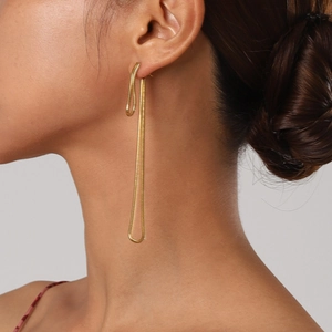 Detail shot of long 18k gold-plated snake chain earrings on a model with elegant drape