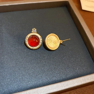 Détail de boucles d'oreilles rétro en agate avec dos doré texturé et tiges en argent