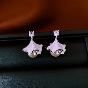 Elegant silver pearl earrings with zircon ginkgo leaf design on a black leather box