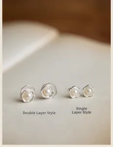 Macro shot of silver double-layered lotus pearl earrings with brushed metal texture