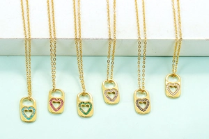 Detail view of heart-shaped cutout lock pendants with multi-colored cubic zirconia in gold