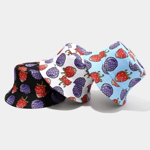 Detailed view of three reversible bucket hats in black, white, and blue with berry prints