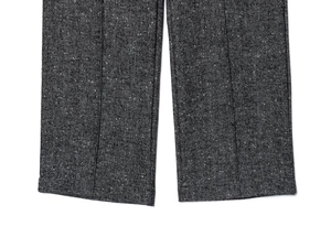 Vista macro dei pantaloni in lana a spina di pesce grigio scuro con trama spessa e orlo cucito