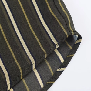 Detail view of colorful striped fabric with professional rolled hem and fine stitching