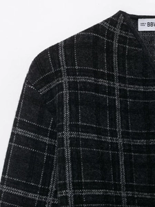 Close-up of dark grey plaid knit sweater showing premium fabric texture and woven patterns