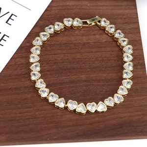 Detailed view of heart-shaped cubic zirconia bracelet on a dark wooden background