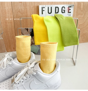 Detailed close-up of ribbed cotton crew socks in vibrant green and yellow colors