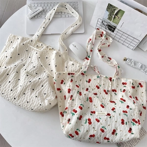 Detailed view of lightweight pleated floral tote bags with drawstring closure on a desk