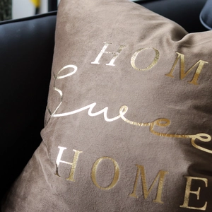 Detail of gold HOME Sweet HOME text on a luxury brown velvet decorative pillowcase