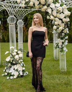 Close-up of elegant black strapless top with high-waisted lace midi skirt details