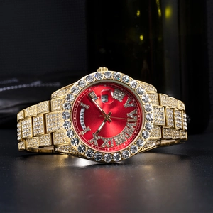 Macro shot of gold-plated iced-out watch with red sunray dial and day-date display features