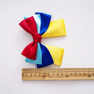 Detail of multi-colored bow hair clip with measuring tape showing 10cm size
