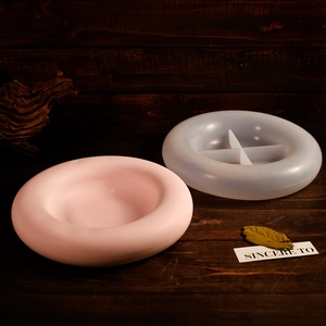 DIY round tray silicone mold for resin casting with pink plaster finish on wooden background