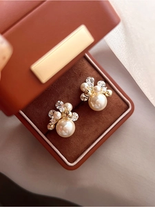 Gros plan de boucles d'oreilles perles plaquées or 18k avec zircons en écrin