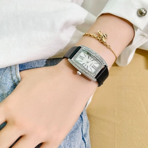Fashionable square silver watch with rhinestones and black leather strap worn on wrist