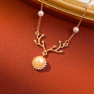 Elegant gold pearl reindeer necklace with zircon antlers on a luxury textured background