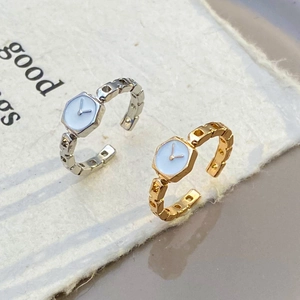 Dettaglio di anelli stile orologio con fasce a catena traforata in oro e argento