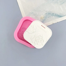 Detailed view of pink silicone mold and white finished rose embossed tag for DIY baking