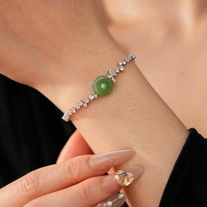 Close-up of zircon silver bracelet with green chalcedony ring on woman's wrist