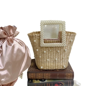 Handmade straw bucket bag with pearl embellishments and pink satin drawstring liner