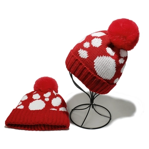 Winter-Strickmütze mit roten und weißen Punkten und großem Kunstfell-Bommel-Detail
