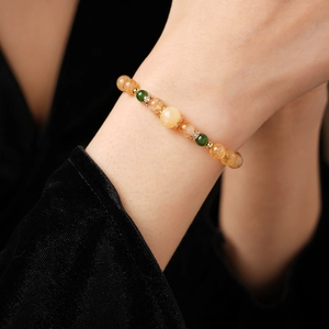 Détail d'un bracelet en perles de citrine jaune et perles de jade vert portées au poignet