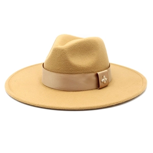 Detail of camel wool felt fedora featuring a ribbon band and a gold bee metal buckle