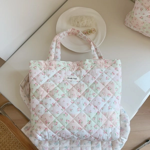 Detailed close-up of pink floral quilted cotton tote bag featuring a simple wish woven label