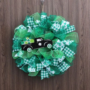 Detailed view of St. Patrick's Day wreath featuring green ribbons and black clover truck