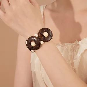 Bohemian geometric coconut shell and wood bead stretch bracelet on a female model