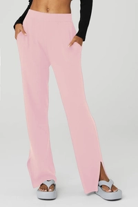 Dettaglio dei pantaloni yoga rosa a gamba larga testurizzati con spacchi laterali alla caviglia