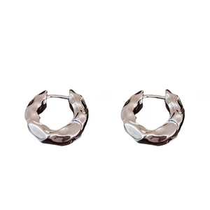 Minimalist silver hoop earrings with a textured molten metal finish on white background