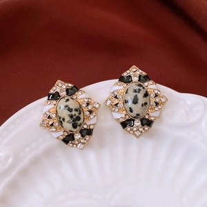 Détail macro de boucles d'oreilles vintage en forme de losange avec émail et pierre