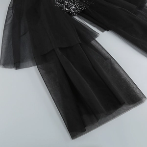 Detail of black tiered tulle skirt featuring dense silver sequins and layered ruffles