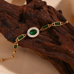 Detail of 18K gold-plated bracelet with green emerald stones and white rhinestones