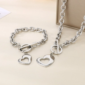 Dettaglio collana e bracciale in acciaio inox argento con ciondolo a cuore e chiusura OT