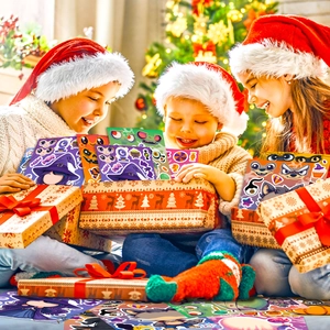 Close-up of three children happily opening Christmas gift boxes filled with colorful stickers
