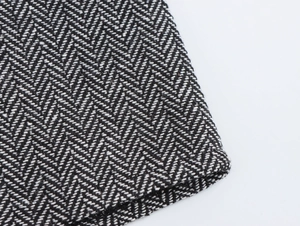 Macro shot of black and white herringbone tweed fabric texture with woven pattern